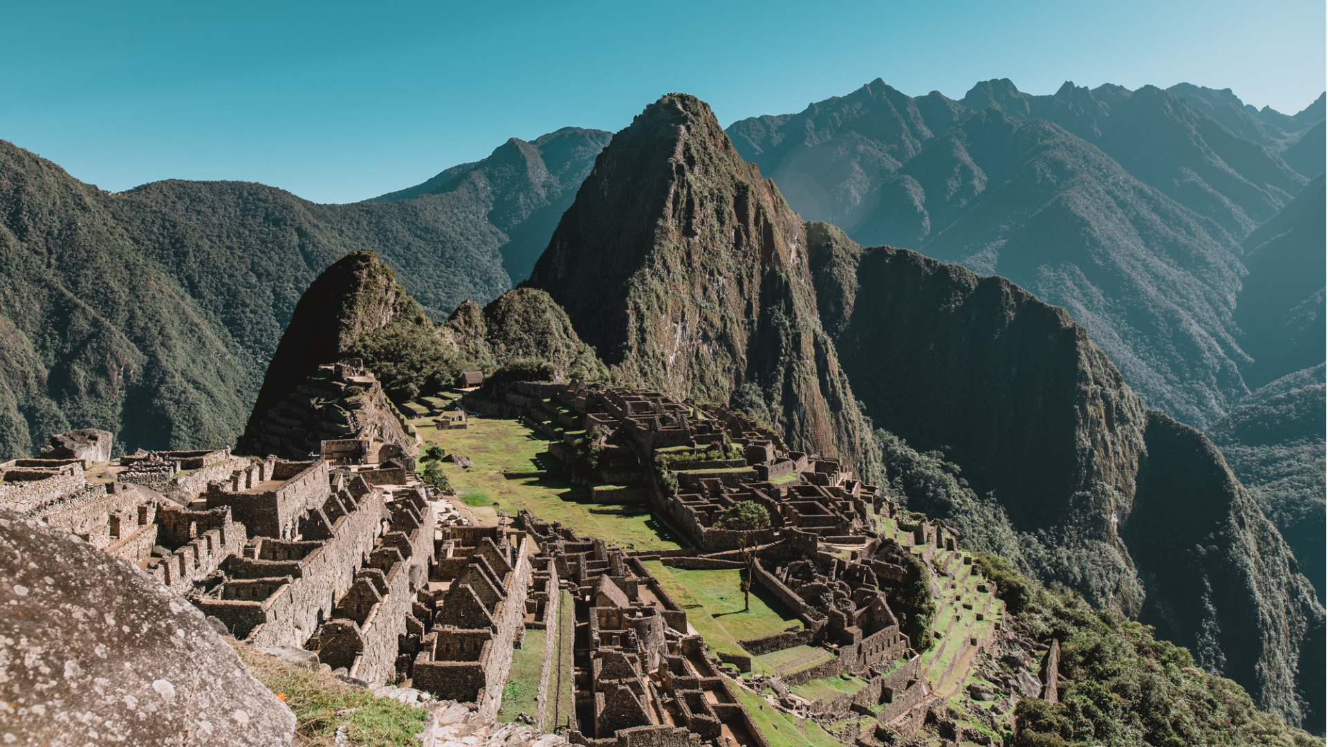 Cittadella inca di Machu Picchu e montagna Huayna Picchu sotto un cielo sereno.