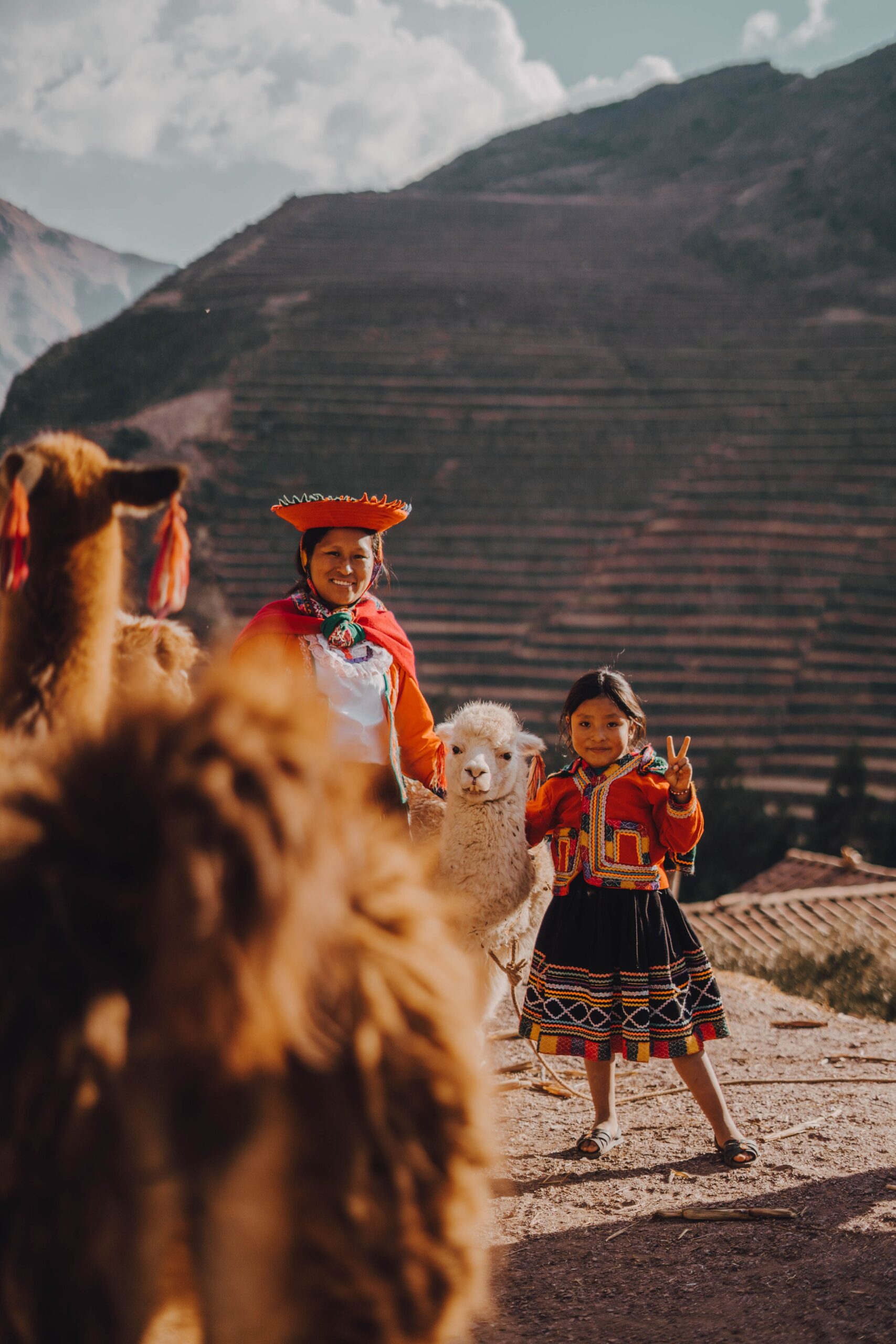 Donna e bambina di una comunità andina con alpaci nel Valle Sacro del Perù