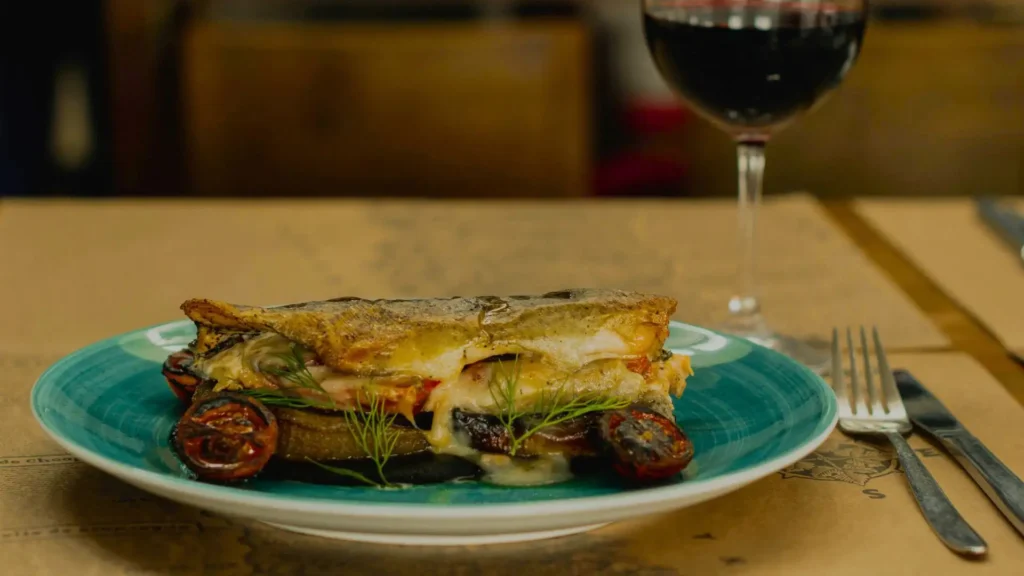 Plato of vegetables and grilled tomatoes served with a glass of Chilean red wine