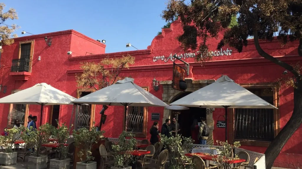 Red facade of the Como Agua para Chocolate restaurant with outdoor tables in the Bellavista neighborhood, Santiago, Chile